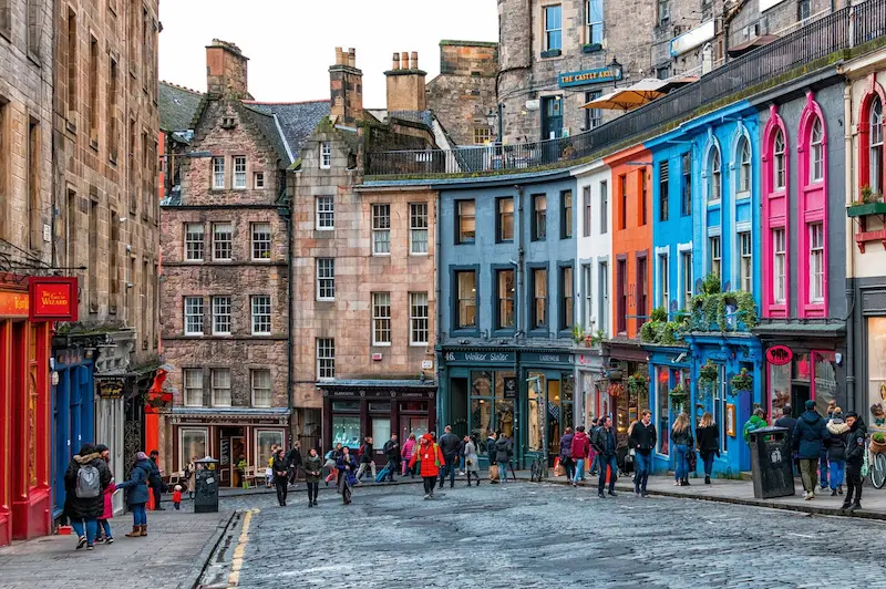 Imagen de la calle de Victoria Street en el corazón de Edimburgo. Es una calle de piedra en cuesta llena de casitas de colores.