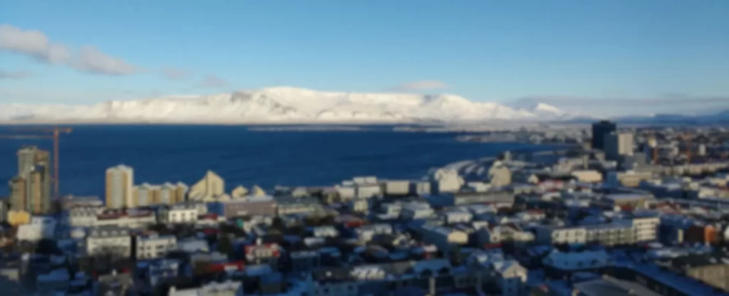 Dónde dormir en Reikiavik - vista aérea de la ciudad de Reikiavik con montañas nevadas al fondo
