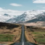 Carretera de Islandia con montañas nevadas al fondo